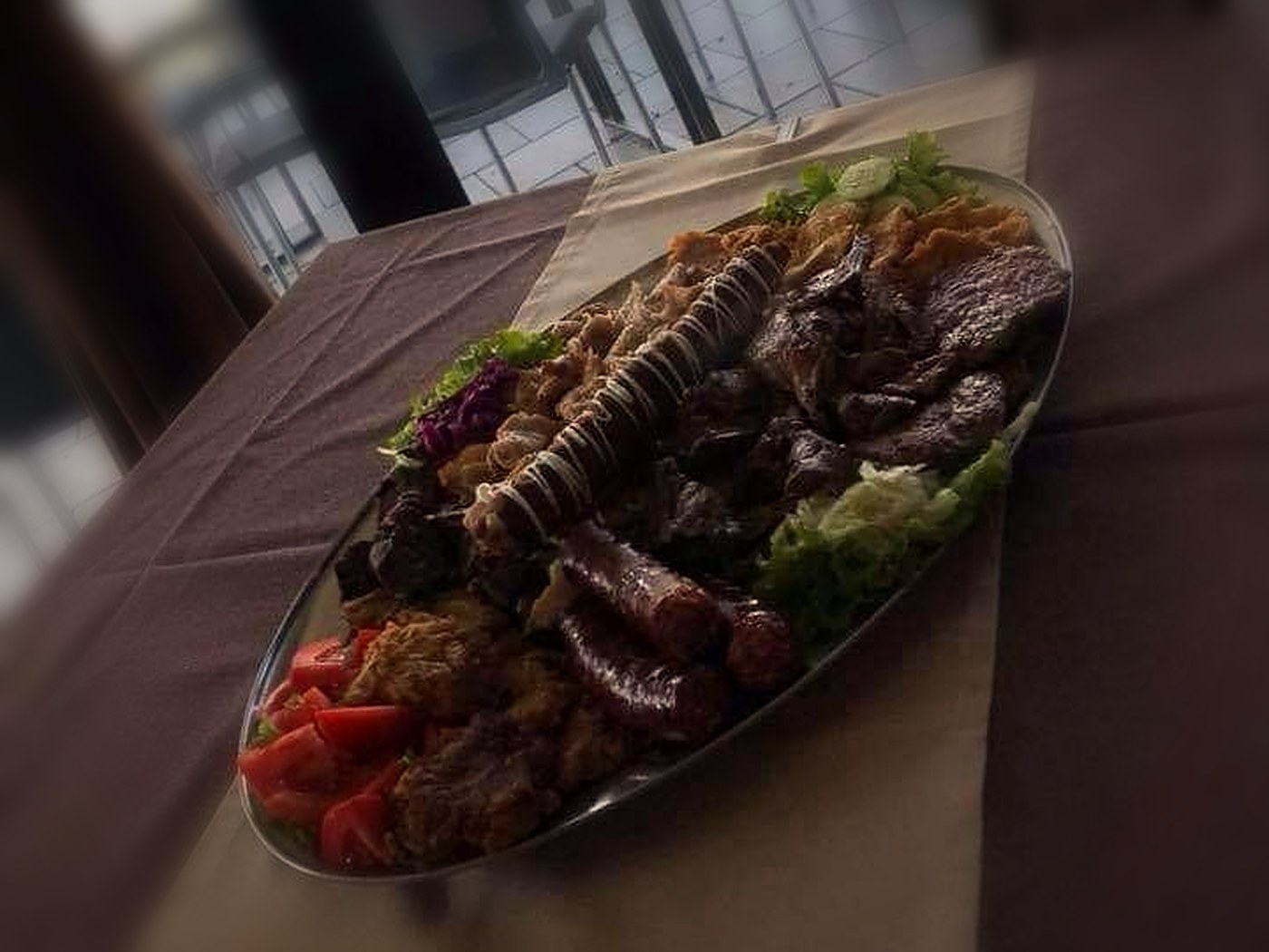 Pjatë e madhe me mish në zgarë mbi tavolinë